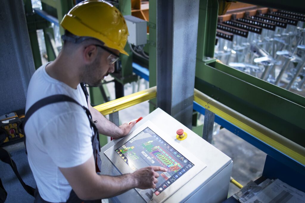 Factory worker monitoring industrial machines and production remotely in control room. - ComputerLearn